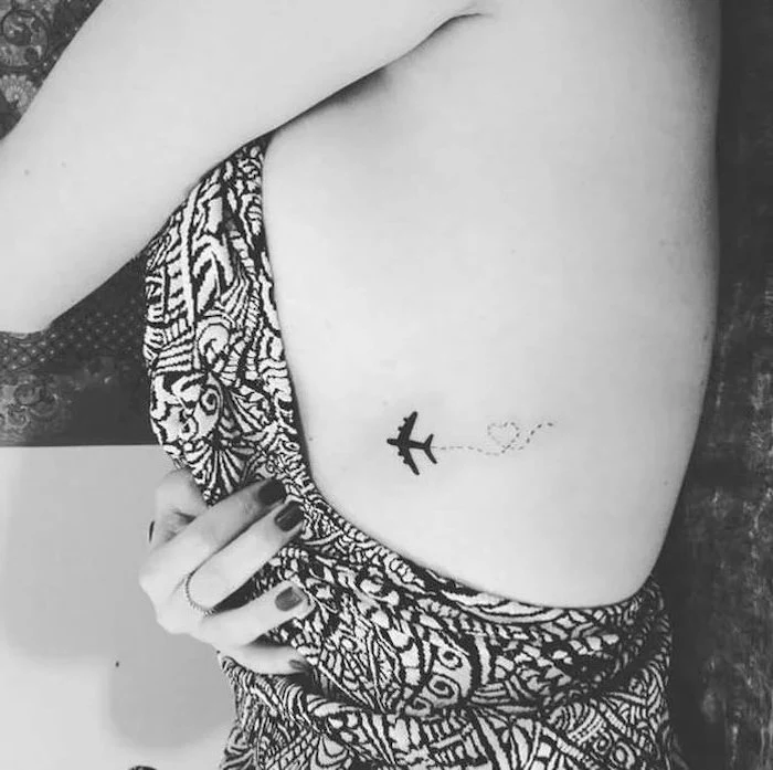 plane and a heart, tattoo on the chest, black and white top, tattoos for girls on wrist, black nail polish
