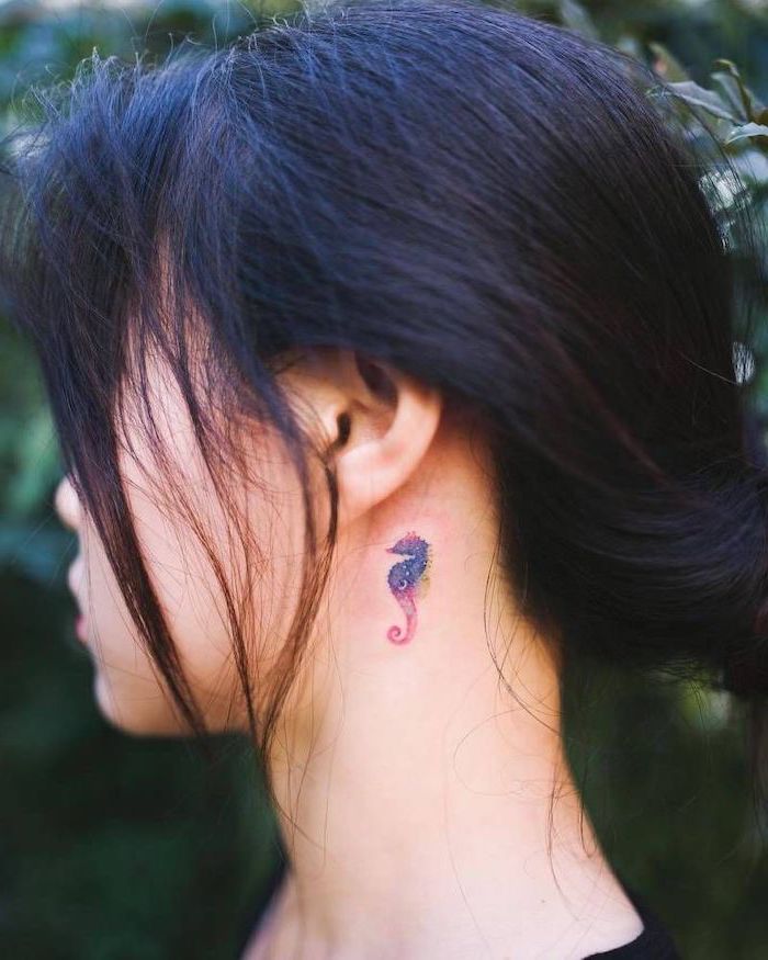 purple and pink seahorse, tattoos for girls, tattoo behind the ear, black hair in a bun