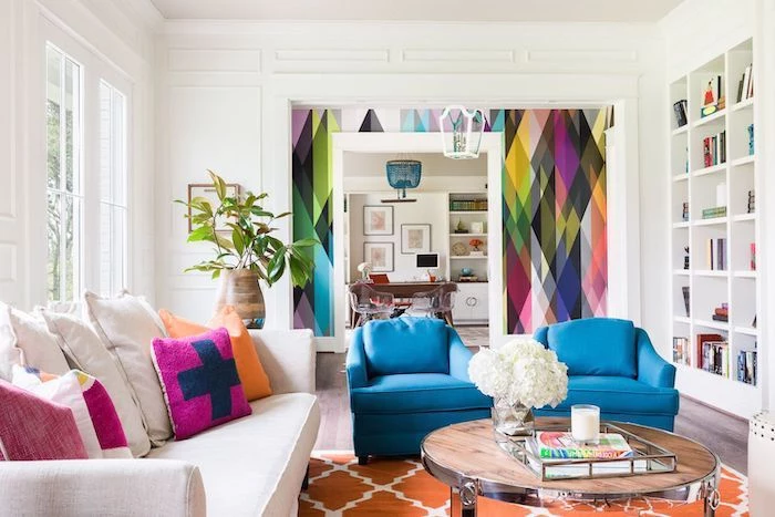 blue armchairs, white sofa, accent wall ideas bedroom, rainbow wallpaper, orange rug
