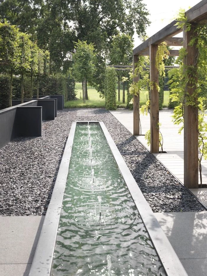gravel pathway, small fountains, desert landscaping ideas, vines on a wooden structure, tall trees