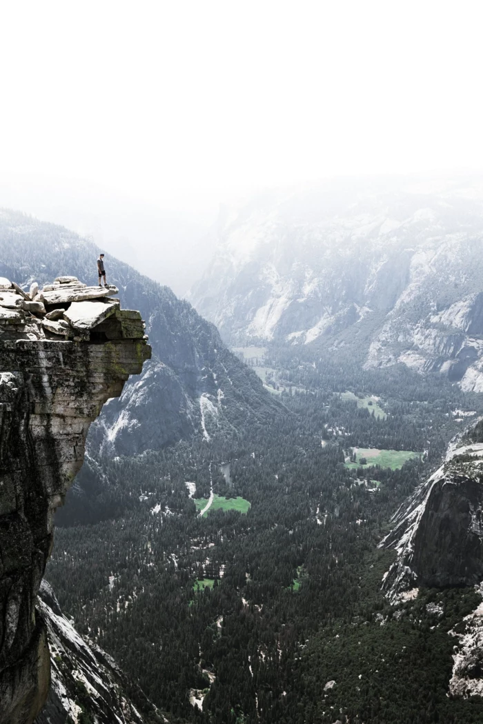 man climbing rocks, iphone wallpaper high quality, green trees and fields and mountains