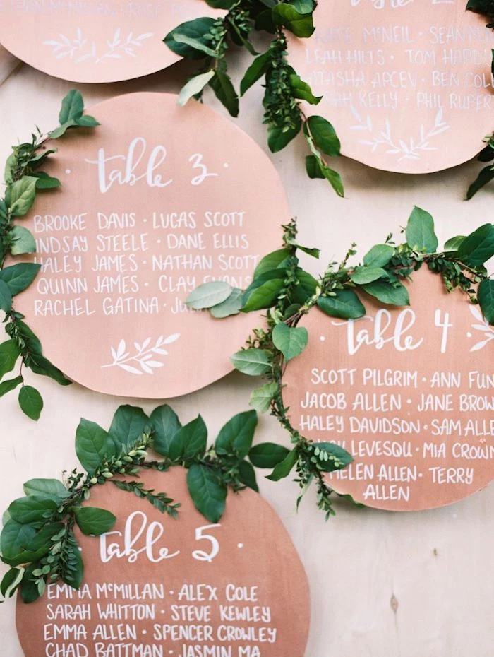 copper round seating chart with green leaves, wedding table decoration ideas