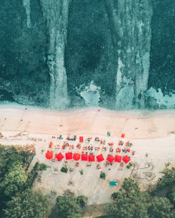 simple iphone wallpaper, red umbrellas, turquoise water, people on the beach