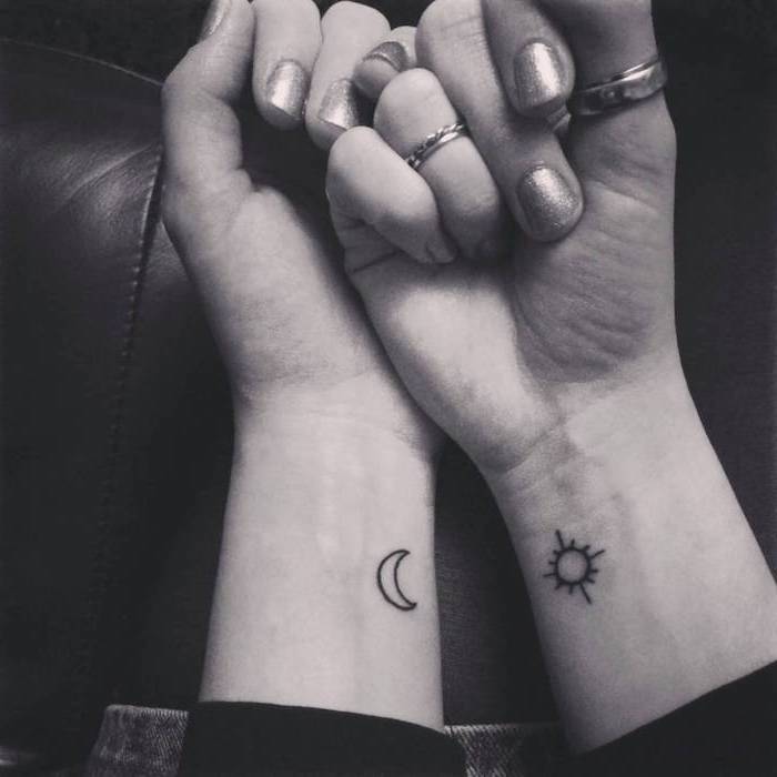 sun and moon, tattoo on both wrists, rings on the fingers, chest tattoos for females