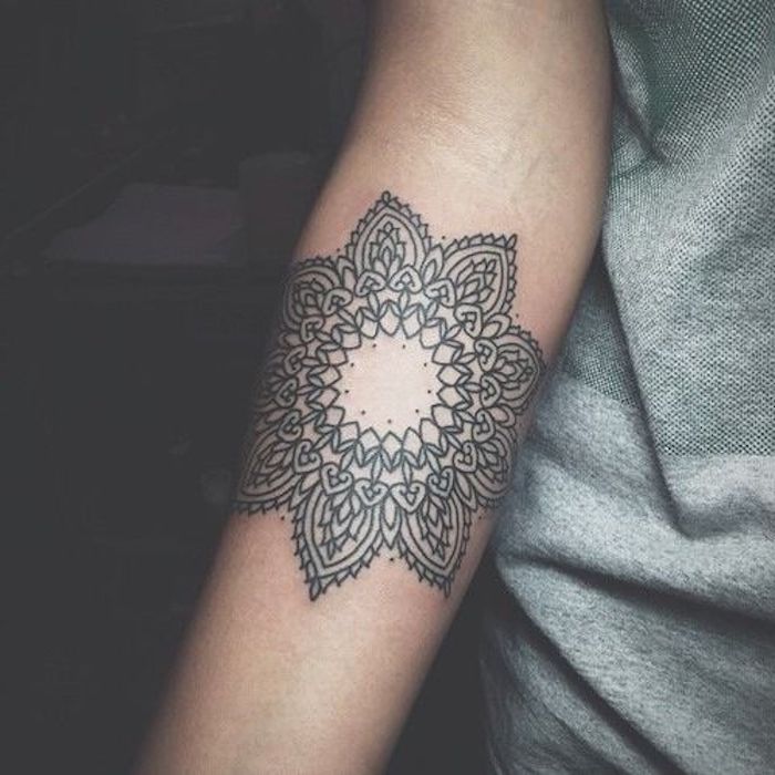 symmetrical flower forearm tattoo, grey top, black background, tattoos for girls on hand, unique hidden meaning tattoos