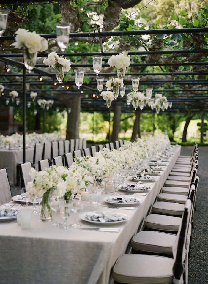 candles and white flower bouquets hanging from the ceiling, white bouquets on the table, wedding ideas for spring