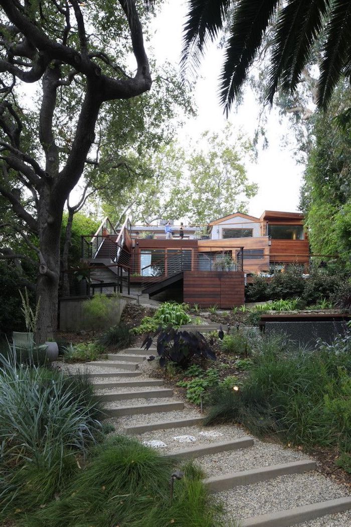 staircase made of gravel, patches of bushes and grass, tall trees, hillside landscaping ideas