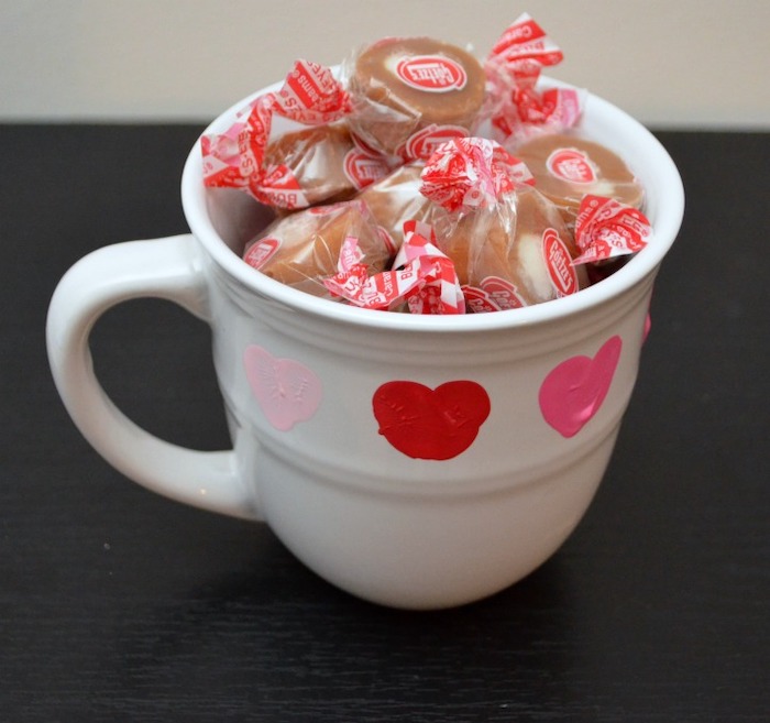 white mug filled with candy, red and pink heart shaped thumbprints, valentine's day gifts for boyfriend