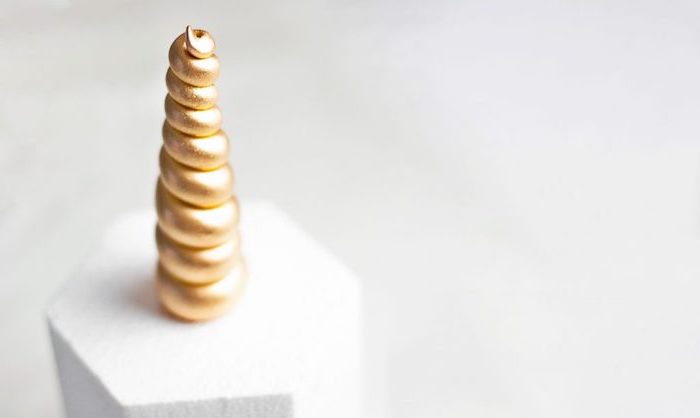 horn painted in gold on styrofoam, white background, unicorn birthday cake