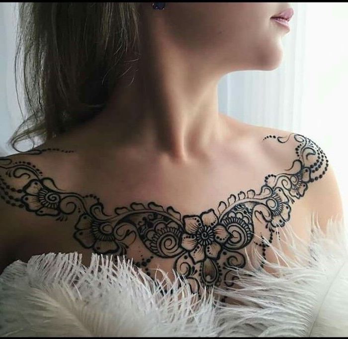 white feathers, symmetrical flowers tattoo on shoulders, brown hair, unique tattoos for women, tattoo designs on chest for females