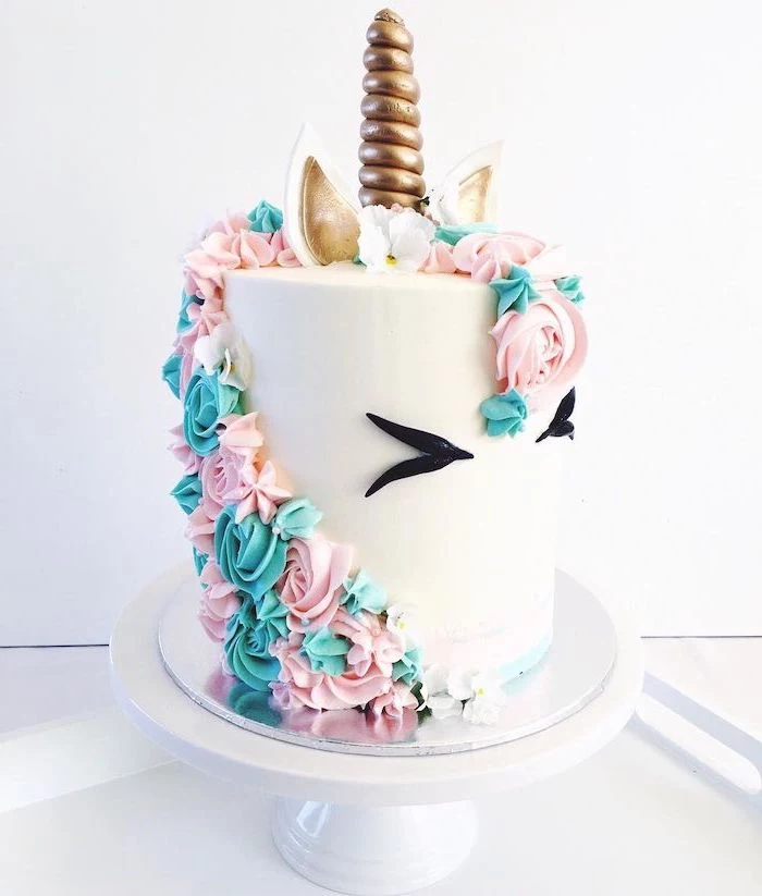 pink and blue roses on white fondant, gold horn and ears, white cake stand, easy unicorn cake