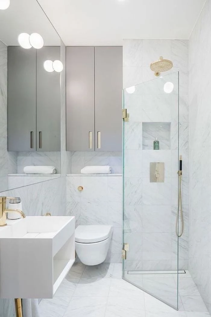 small bathroom decorating ideas, white tiled walls and floor, glass shower door, grey cabinets, floating sink