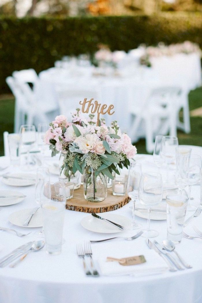 wooden centrepiece with a table number, pink and white flower bouquet in vases, diy wedding decorations