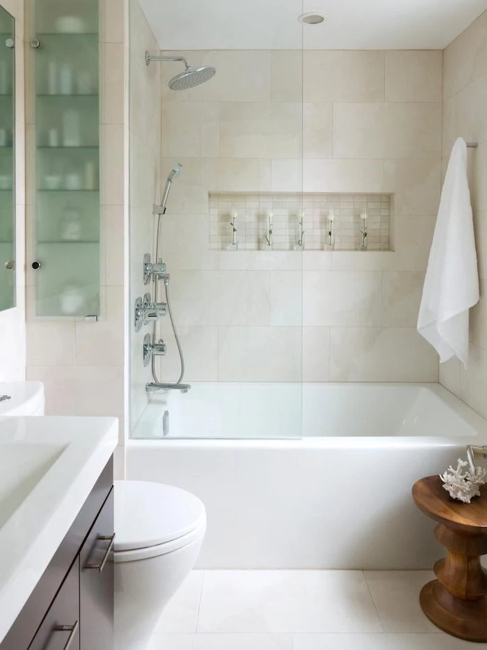 white tiled walls and floor, wooden stool and cabinets, modern bathroom design, glass shower door