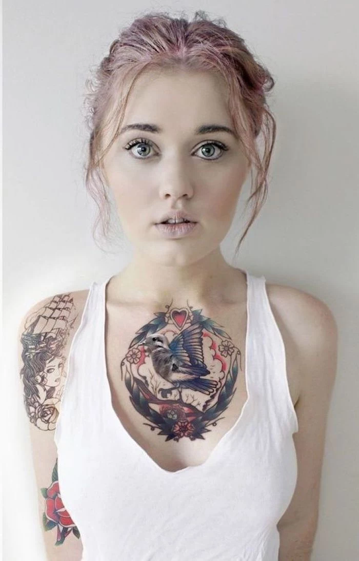 pin hair in a bun, unique tattoos for women, white top, bird and hearts tattoo, white background