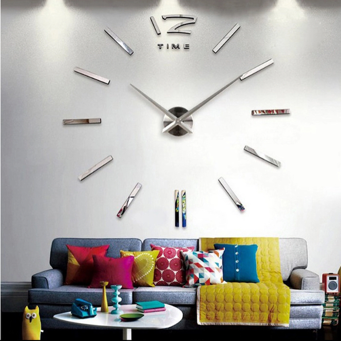 grey sofa, white wall with a large clock installation, wallpaper accent wall