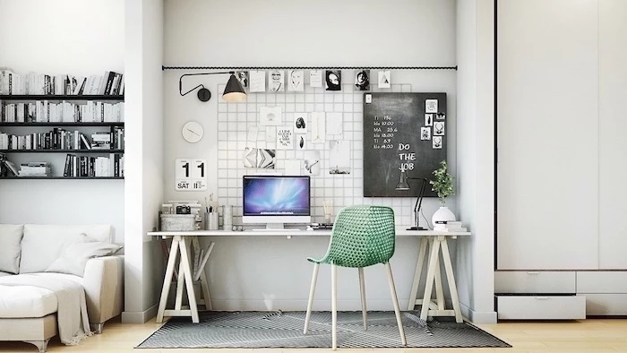 wooden desk, green mesh chair, chalk board, office pictures, black bookshelves, dark grey rug