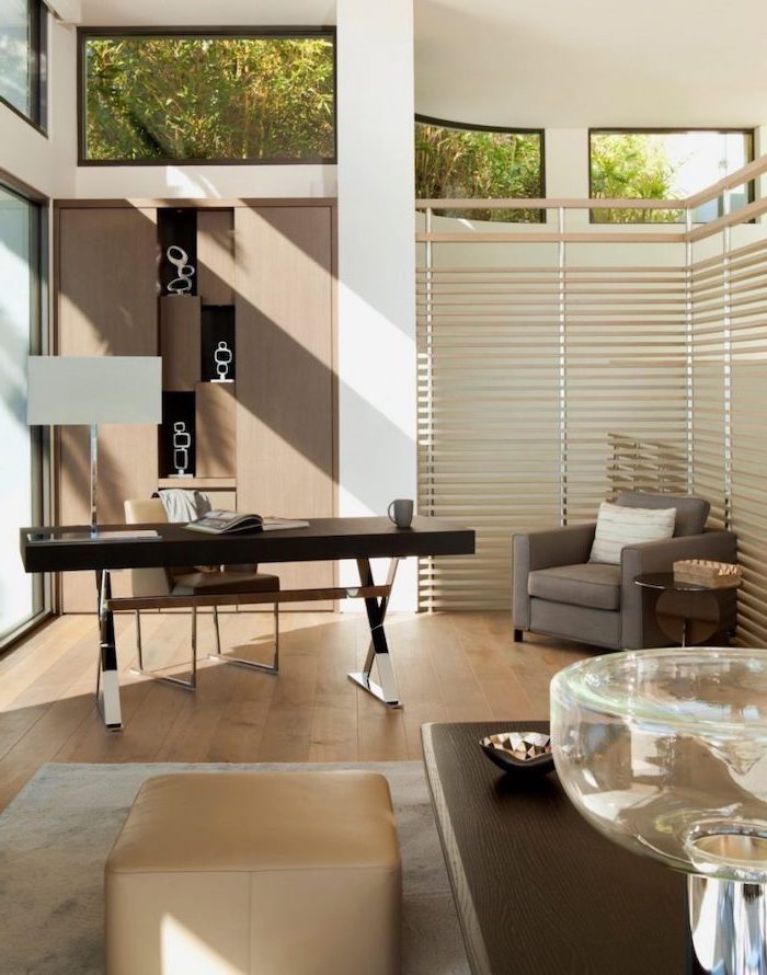 wooden bookcase and floor, wooden desk, living room desk, beige leather chair and stool, grey armchair