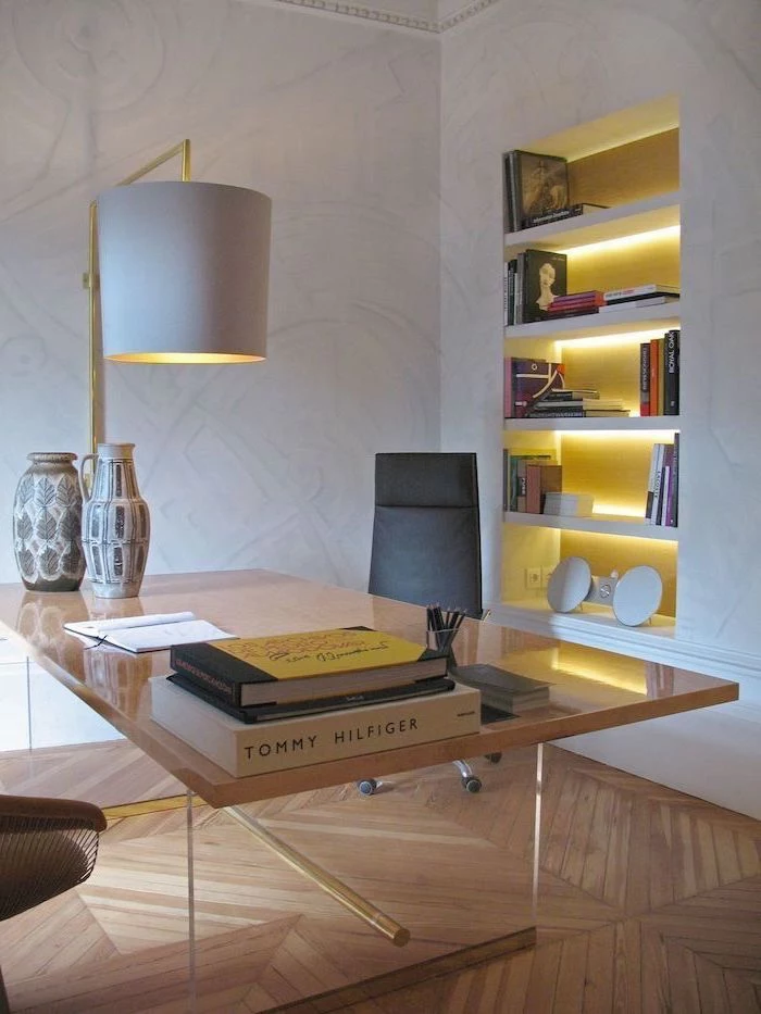 metal desk, white bookshelves and desk lamp, black leather chair, living room desk, wooden floor