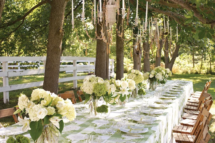 white flower bouquets in vases, hanging candelabrums, wooden chairs, fall wedding ideas