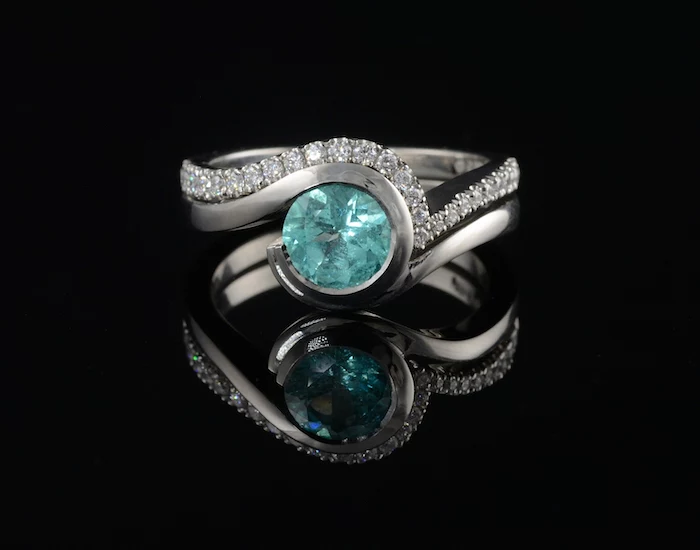 round aquamarine stone, black background, gold engagement rings, diamond studded band