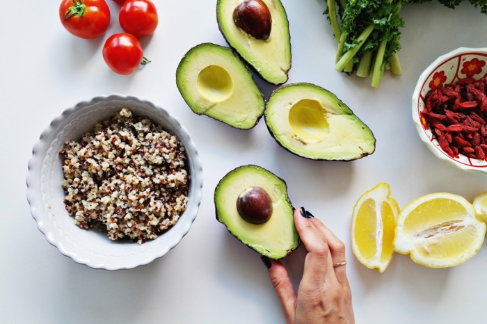 sliced avocados, quinoa salad, in a white bowl, slices of lemon around, balanced diet, bowl of goji berry