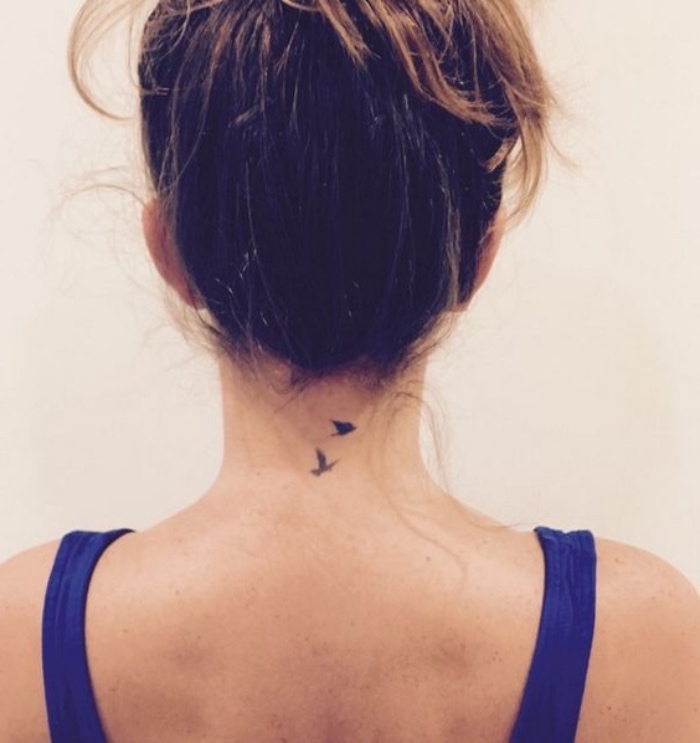 brown hair in a messy bun, small tattoos for men, birds flying away back tattoo, blue straps