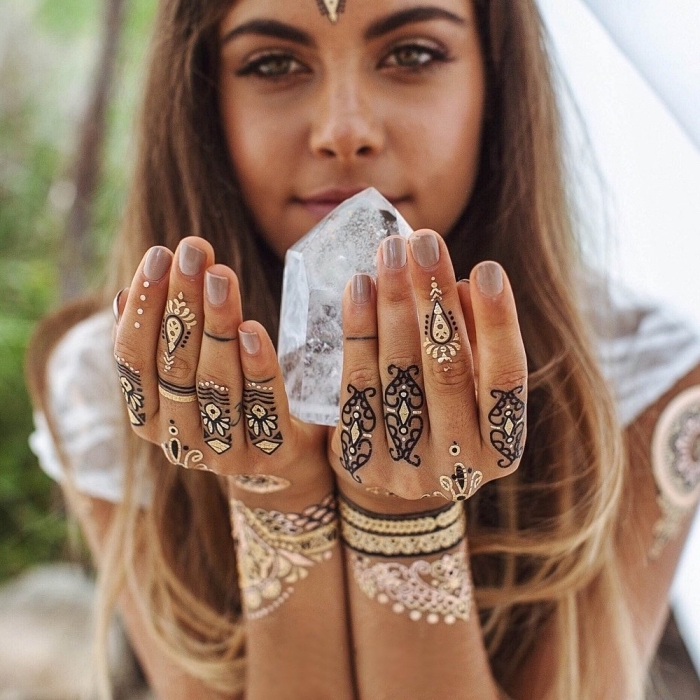 girl holding a crystal, black and gold henna tattoo, temporary tattoo, ring finger tattoos