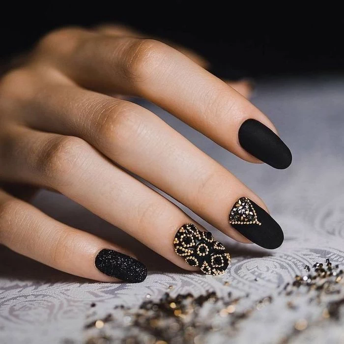 nail designs, black matte nail polish, many little stones and crystals, on two nails, black glitter nail polish