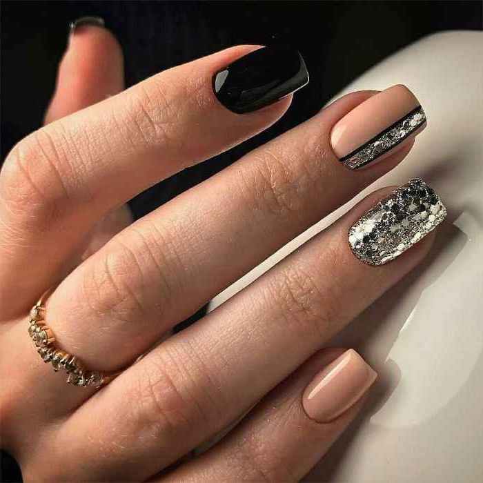 black and nude nail polishes, silver glitter nail polish, nail art designs, golden ring on the middle finger
