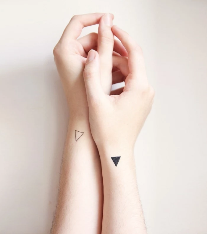 a set of hands, small black and white triangles, on both hands, white background, geometric tattoo sleeve