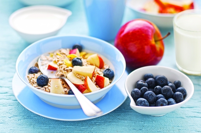 yogurt with oats, apples and blackberries, inside a blue bowl, healthy weekly meal plan, on a blue plate