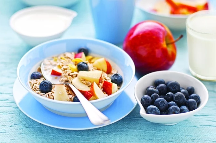 yogurt with oats, apples and blackberries, inside a blue bowl, healthy weekly meal plan, on a blue plate