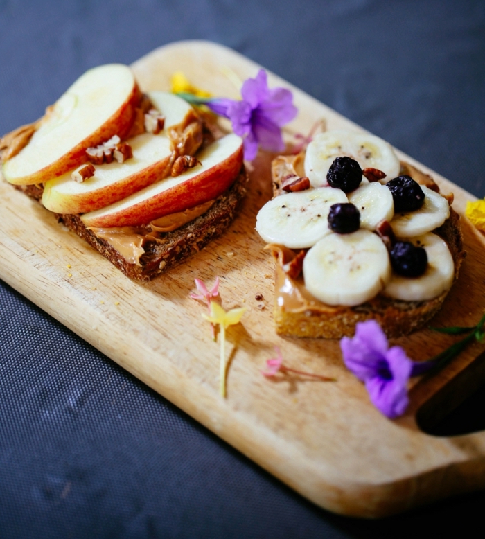 wooden cutting board, slices of bread on top, what should i eat for lunch, apple and banana slices