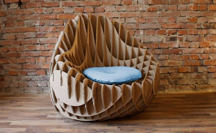 minimalist modern design, cardboard chair, in front of a brick wall, with a blue pillow