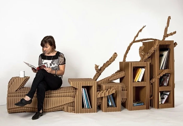 diy cardboard, chair and bookshelves, woman sitting and reading, intricate design, furniture made of cardboard
