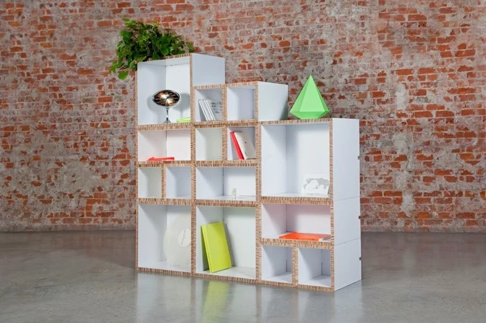 large cardboard bookshelf, painted in white, cardboard furniture diy, in front of a brick wall