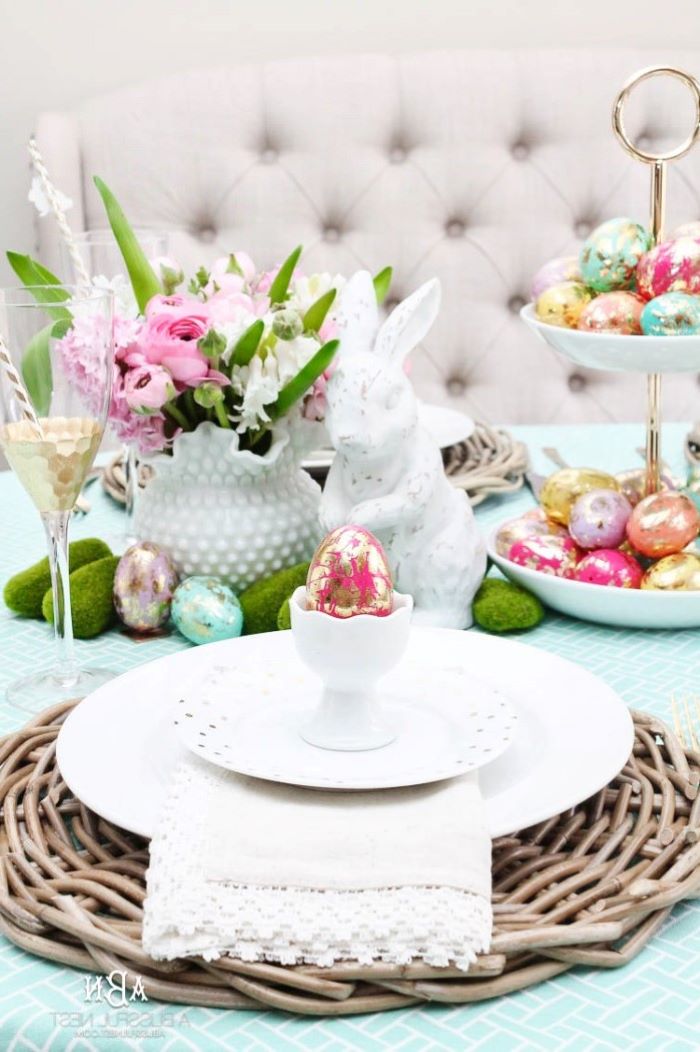 white plate settings, ceramic bunny figurine, dyed eggs on a cake stand, simple table decorations