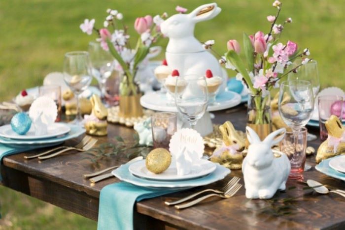 ceramic bunny figurines, simple table decorations, blue napkins, bouquets of flowers, dyed eggs