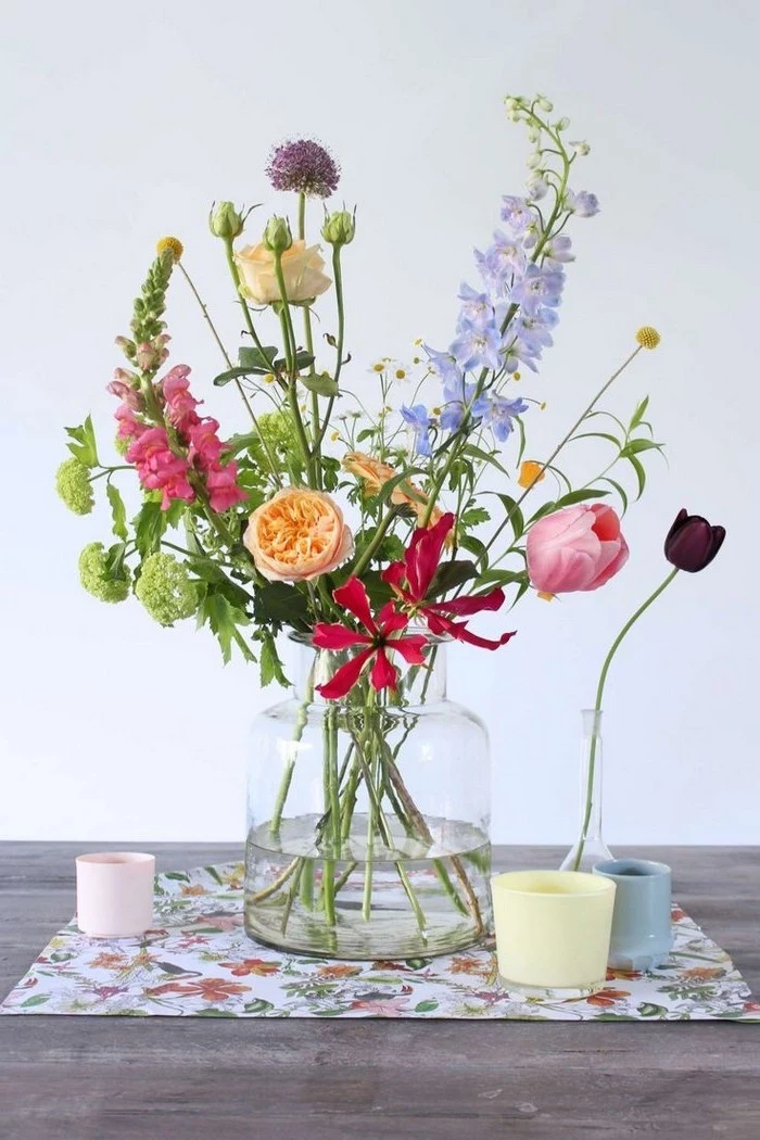 large glass vase, colourful flower bouquet, floral centerpieces, on a wooden table, in front of a white background