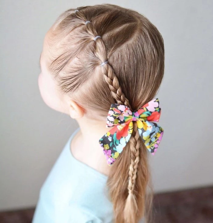 floral bow, long blonde hair in a ponytail and braid, blue shirt, short hairstyles for girls