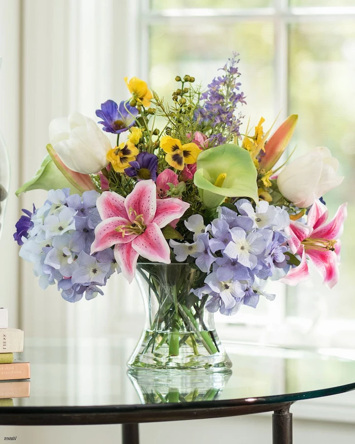 colourful flower bouquet, filled with different flowers, flower arrangements, glass vase on a glass table