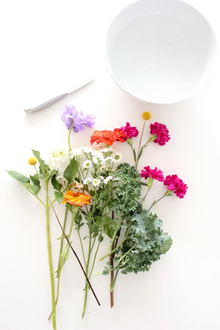 white round vase, colourful flowers and a knife, on a white countertop, flower centerpieces, diy tutorial