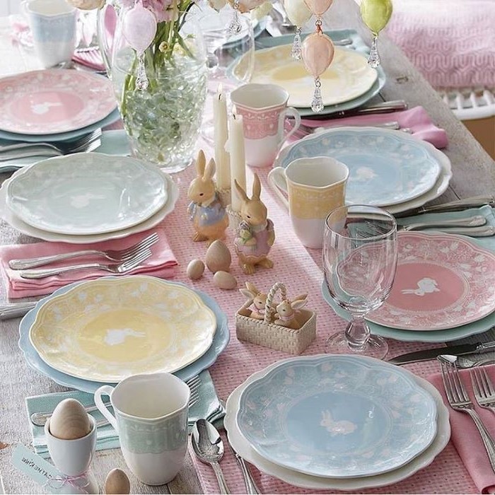 table settings with colourful plates, ceramic bunny figurines, easter table decorations