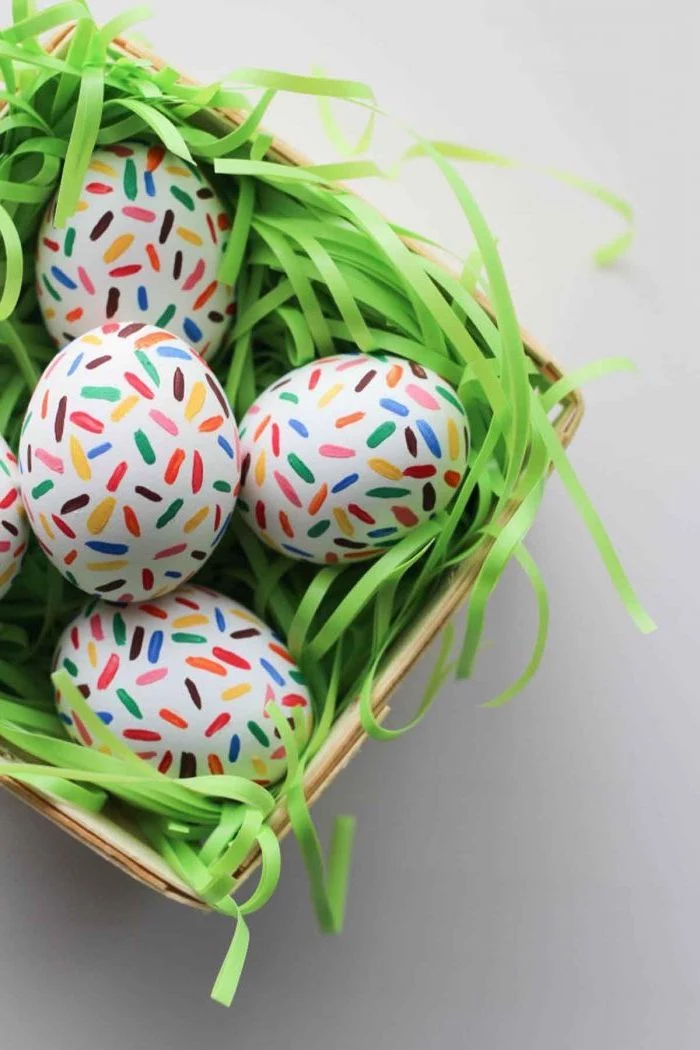 chocolate sprinkles eggs, in a wooden basket, natural egg dye, colourful sprinkles, on white eggs