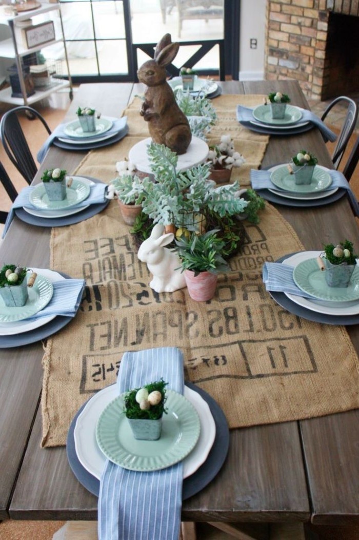 ceramic bunny figurines, easter decorating ideas table setting, blue napkins, across white plates