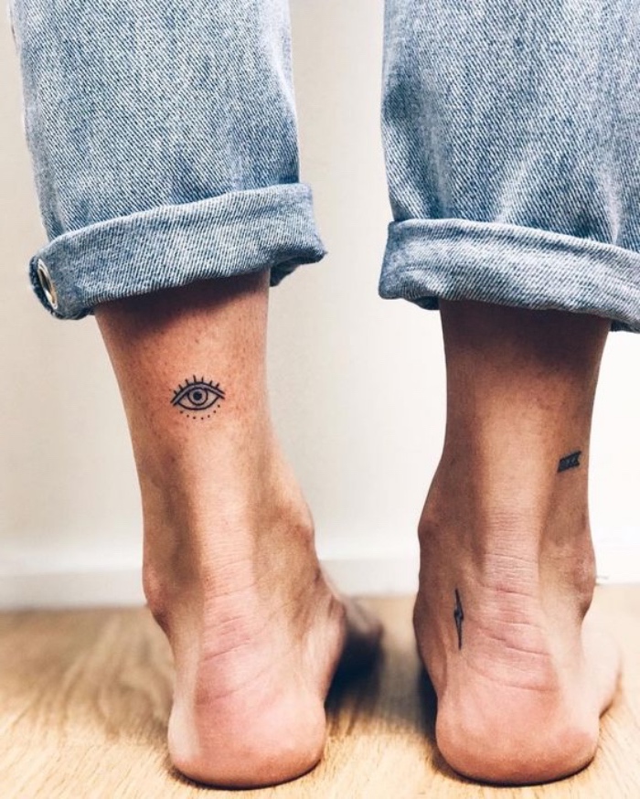 eye lightning bolt and roman numerals ankle tattoos, cool small tattoos, person wearing washed jeans