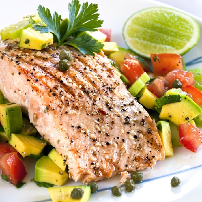 fish fillet, on an avocado salad, with tomatoes and capers, lime slice on the side, diets for women