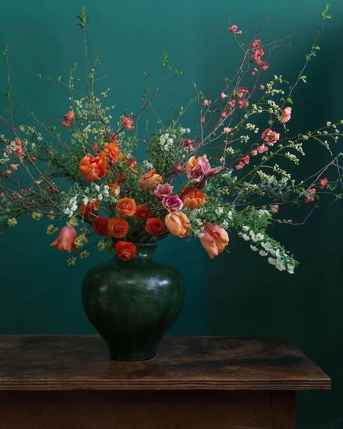 large vintage ceramic vase, colourful flowers bouquet, floral centerpieces, in front of a turquoise background