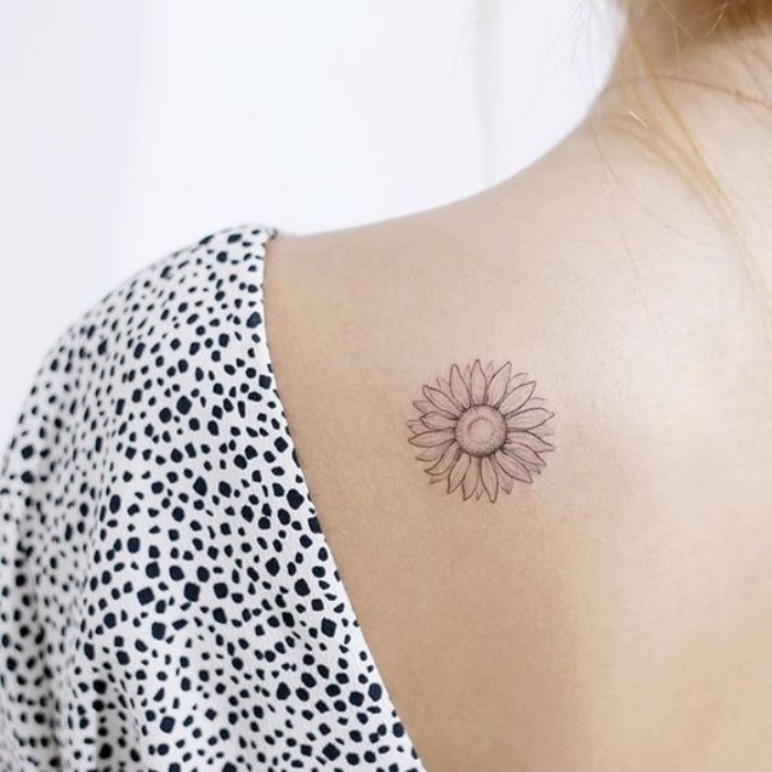 woman wearing a black and white top, sunflower shoulder tattoo, small meaningful tattoos